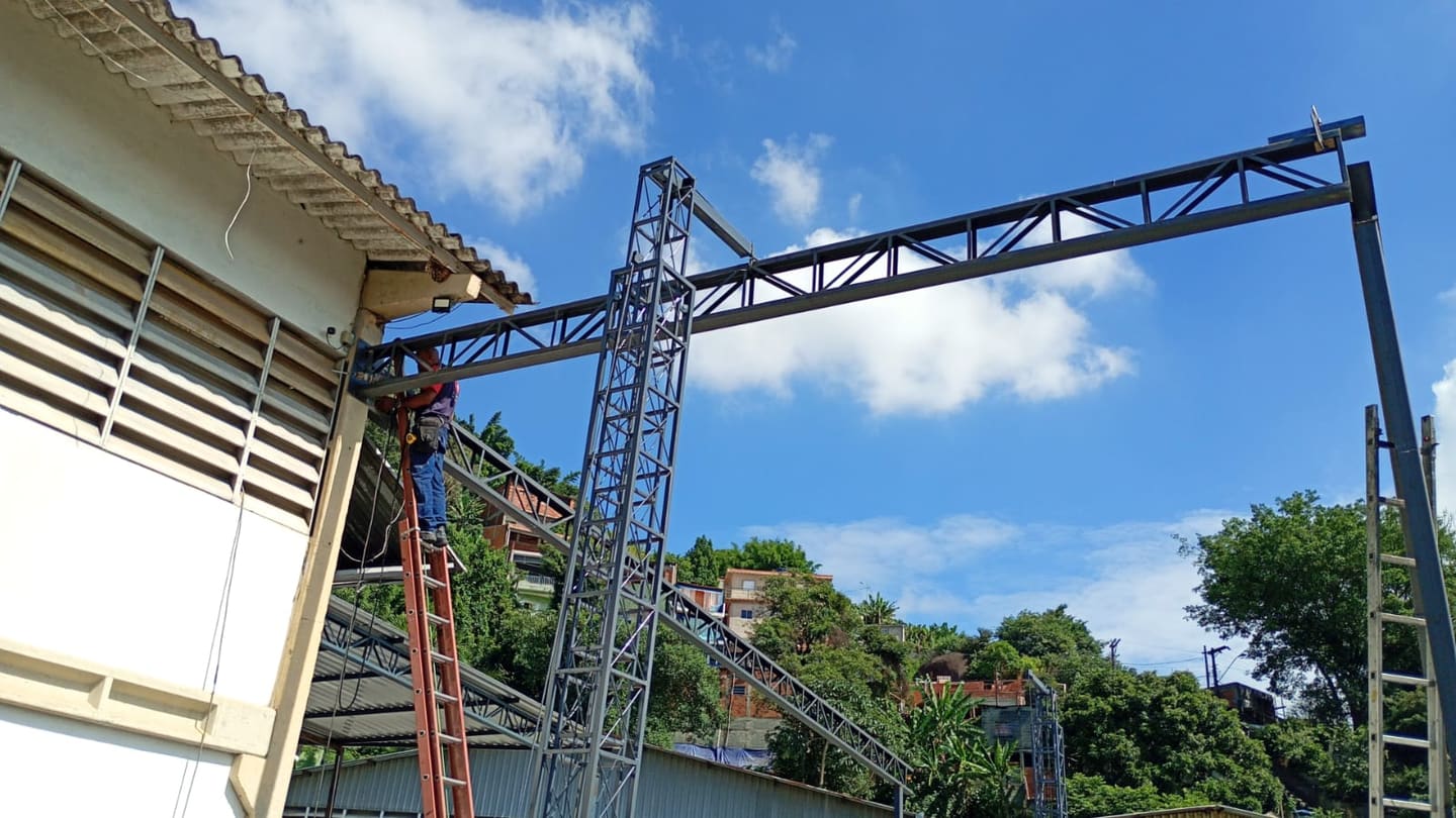Profissional da Serralheria RPS trabalhando na montagem de uma estrutura metálica treliçada